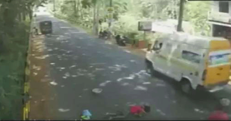 Onlookers pass by as woman lies on road after hit by bike